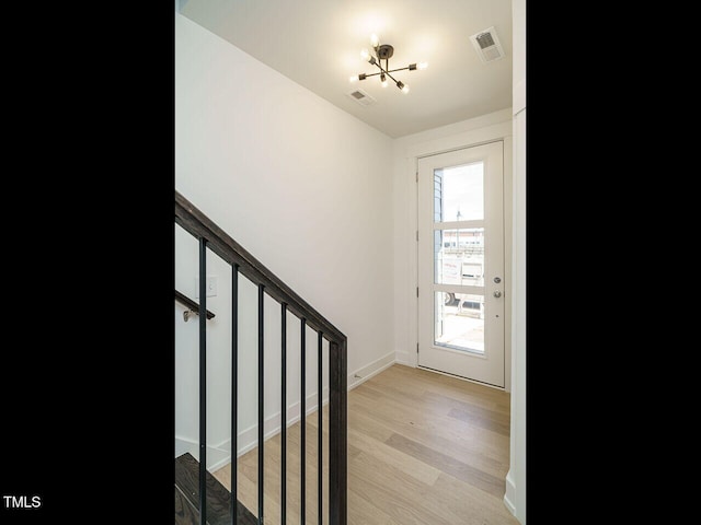 entrance foyer featuring stairs, light wood-type flooring, visible vents, and baseboards