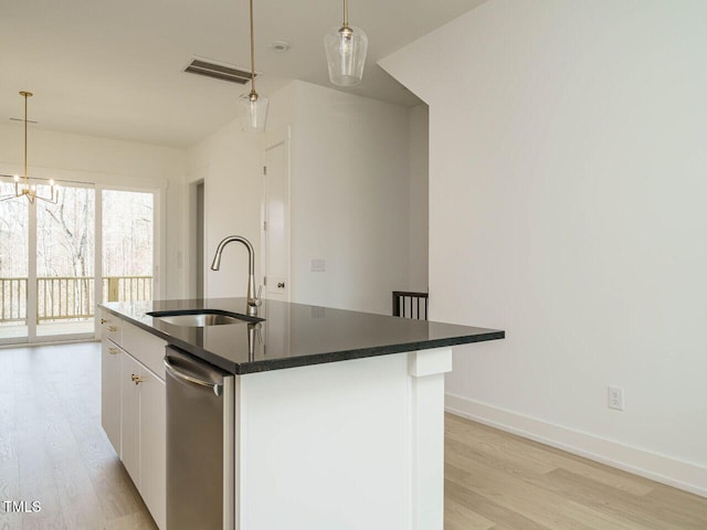 kitchen featuring dark countertops, visible vents, a sink, and light wood finished floors