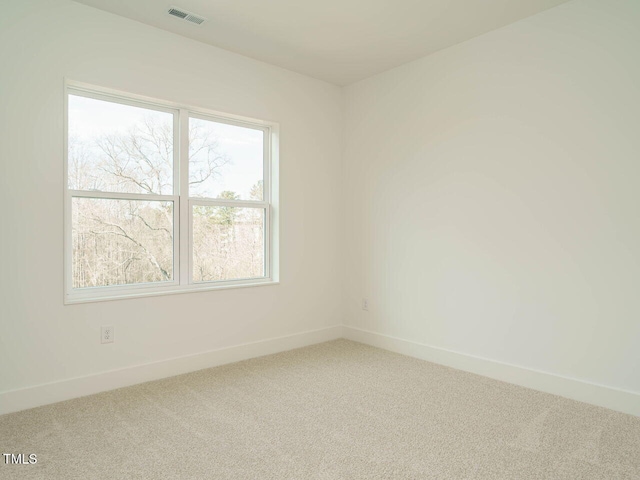 carpeted empty room featuring visible vents and baseboards