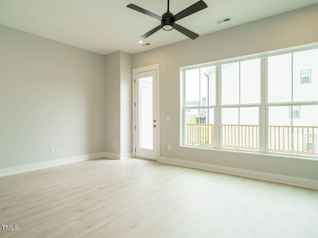 empty room featuring visible vents, ceiling fan, light wood-style flooring, and baseboards