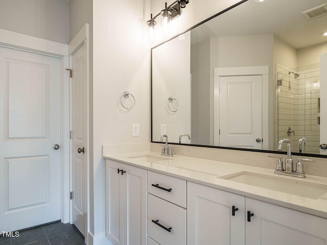 full bathroom with tiled shower, a sink, visible vents, and tile patterned floors