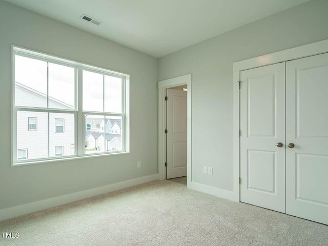 unfurnished bedroom with a closet, baseboards, visible vents, and carpet flooring