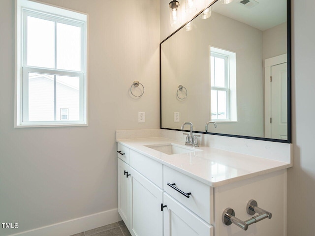 bathroom with tile patterned flooring, vanity, and baseboards