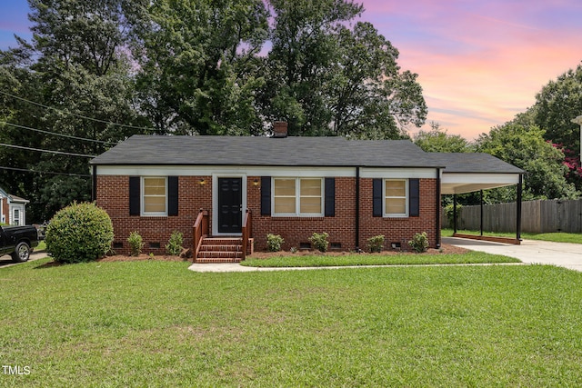 ranch-style home featuring a yard and a carport