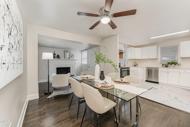 dining room with ceiling fan, dark hardwood / wood-style floors, and a fireplace