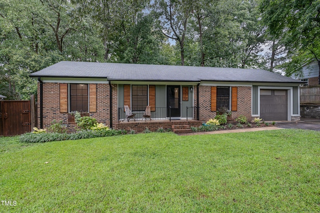 ranch-style house featuring covered porch and a front lawn