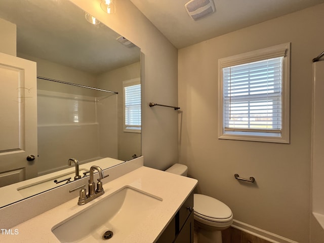 bathroom with vanity, toilet, and walk in shower