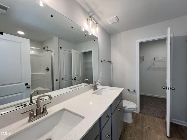 bathroom with a shower with door, wood-type flooring, vanity, and toilet