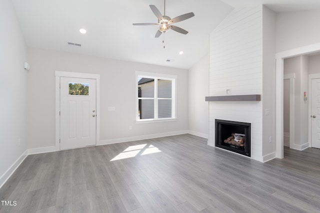 unfurnished living room featuring high vaulted ceiling, a fireplace, light hardwood / wood-style floors, and ceiling fan