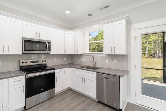 kitchen featuring light stone counters, sink, white cabinets, and appliances with stainless steel finishes