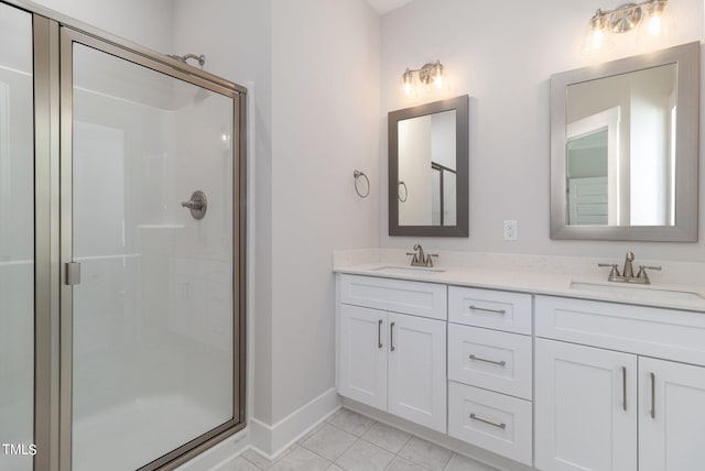 bathroom featuring tile patterned floors, a shower with shower door, and vanity