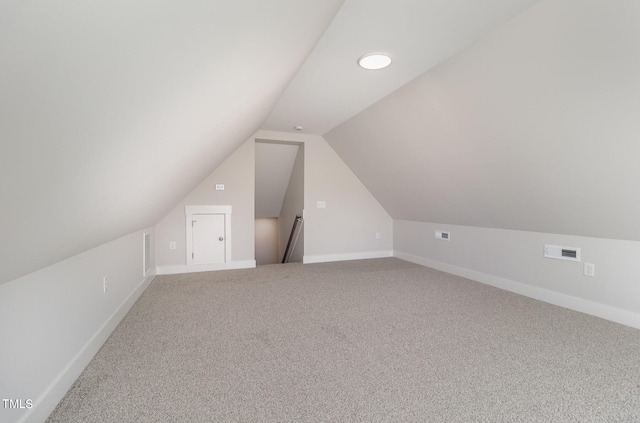 bonus room featuring vaulted ceiling and carpet