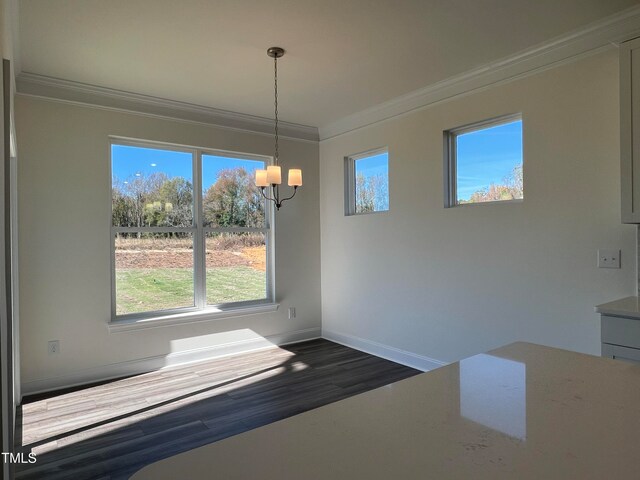 unfurnished dining area with crown molding, dark wood-type flooring, and a chandelier