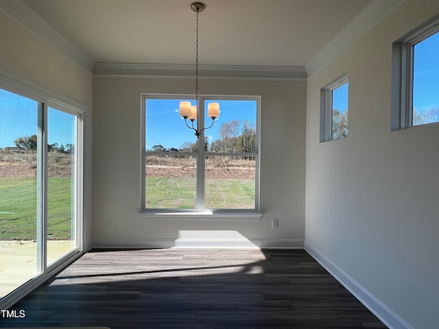 unfurnished dining area featuring crown molding, a wealth of natural light, a chandelier, and dark wood-type flooring