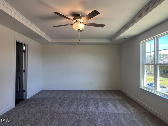 carpeted spare room with crown molding, plenty of natural light, and a raised ceiling