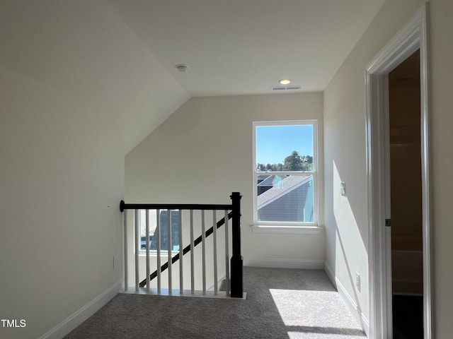 stairway featuring vaulted ceiling and carpet floors