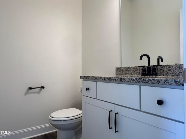 bathroom featuring hardwood / wood-style flooring, vanity, and toilet