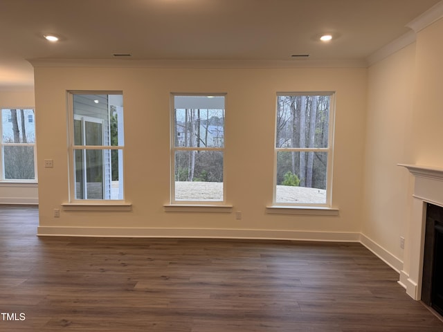 unfurnished living room featuring ornamental molding and dark hardwood / wood-style flooring