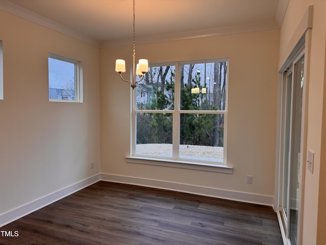 unfurnished dining area featuring an inviting chandelier, crown molding, and dark wood-type flooring