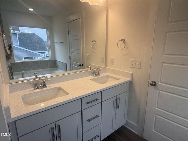 bathroom with vanity and a tub