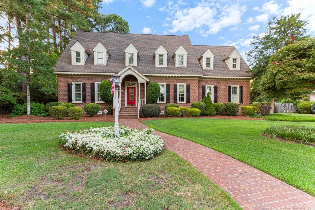 cape cod house with a front yard