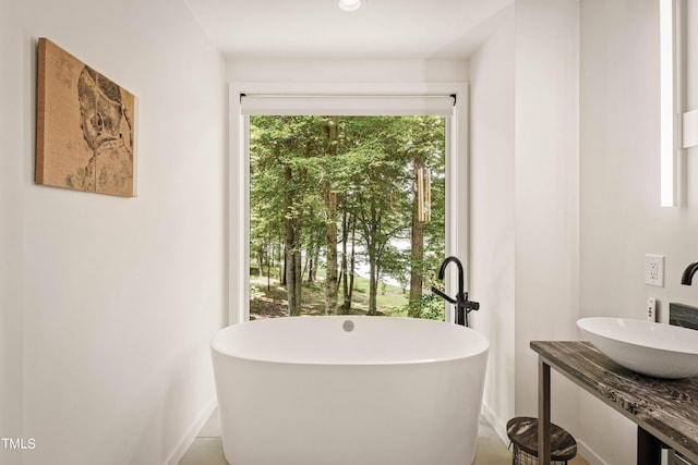 full bathroom with a sink and a freestanding bath