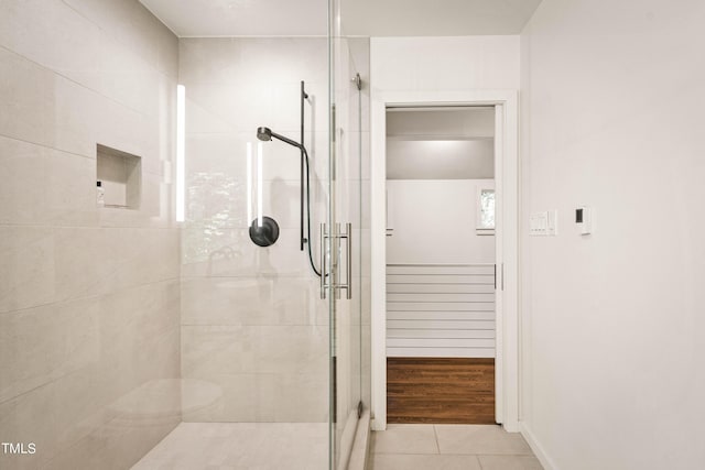 full bath with tile patterned flooring, a stall shower, and baseboards