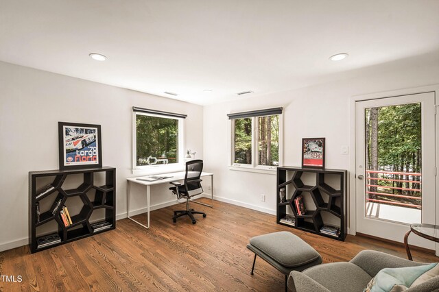 home office with plenty of natural light and hardwood / wood-style floors