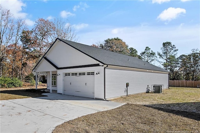 view of side of home featuring a garage and cooling unit