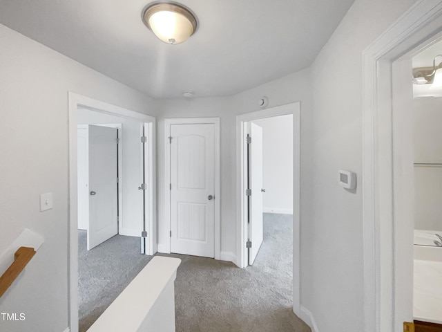 hall with dark colored carpet