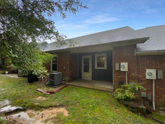 back of property featuring central AC unit and a yard