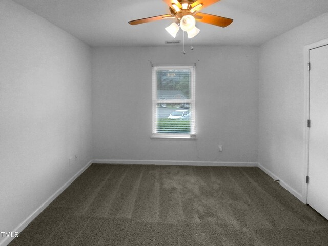 carpeted spare room featuring ceiling fan