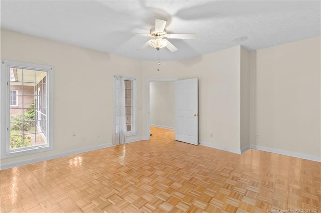 unfurnished room featuring light parquet flooring, a textured ceiling, and ceiling fan