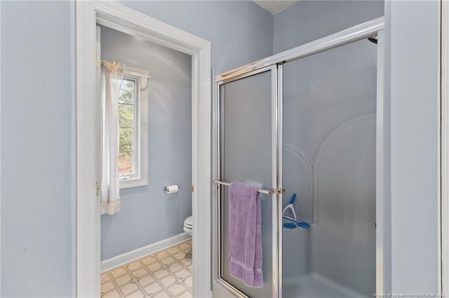 bathroom featuring toilet and a shower with door