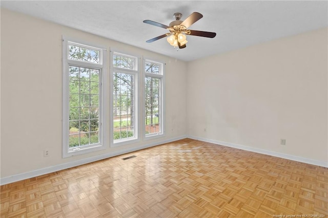 empty room with light parquet floors and ceiling fan