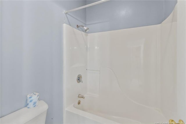 bathroom featuring washtub / shower combination and toilet