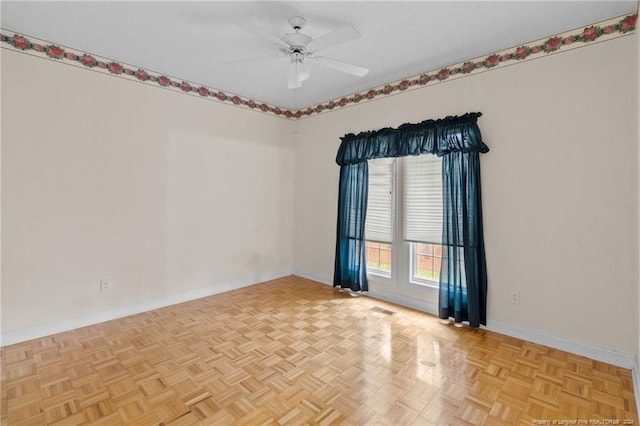 empty room with ceiling fan and light parquet flooring