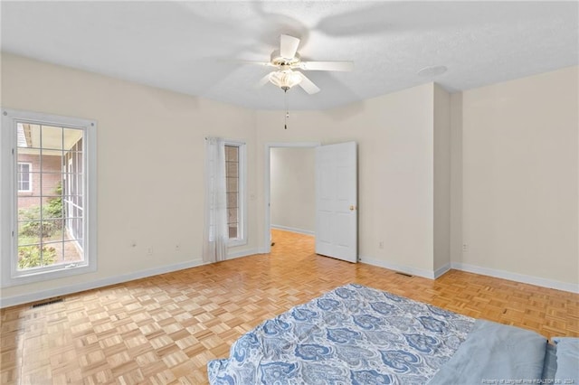 empty room featuring ceiling fan, a textured ceiling, and light parquet flooring