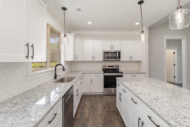 kitchen featuring sink, hanging light fixtures, white cabinets, and appliances with stainless steel finishes