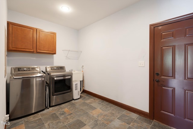 clothes washing area featuring cabinets and independent washer and dryer