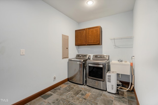 laundry area featuring cabinets, electric panel, and washing machine and clothes dryer