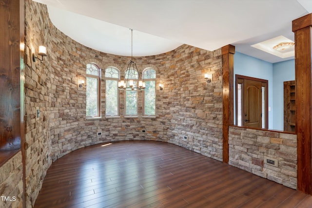 spare room featuring a notable chandelier and dark hardwood / wood-style floors