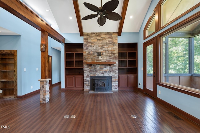 unfurnished living room featuring ceiling fan, dark wood-type flooring, beam ceiling, high vaulted ceiling, and a wood stove