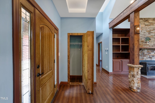 foyer featuring dark hardwood / wood-style flooring and a wood stove