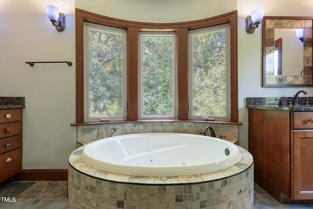 bathroom featuring tiled tub, plenty of natural light, and vanity