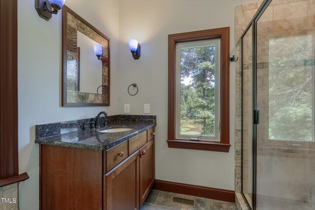 bathroom with vanity and a shower with shower door