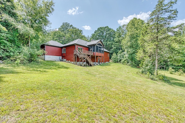 view of yard featuring a sunroom and a wooden deck