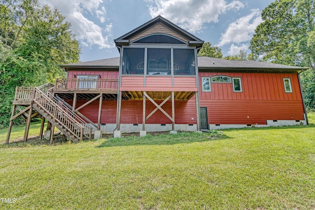 rear view of house with a lawn, a wooden deck, and a sunroom