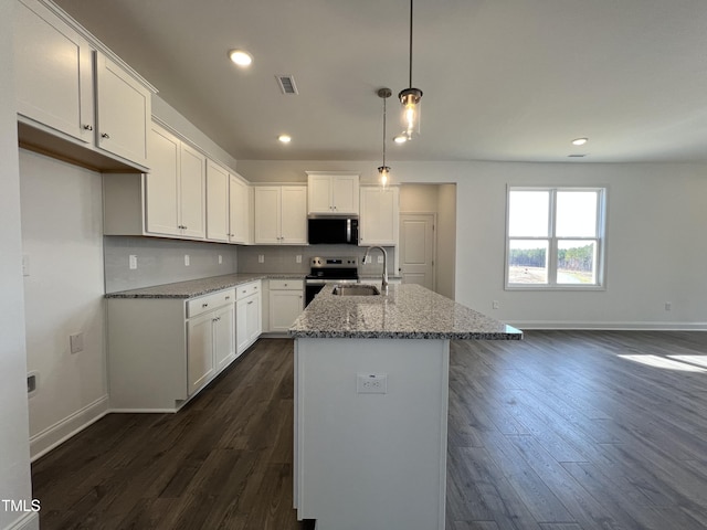 kitchen with appliances with stainless steel finishes, white cabinetry, an island with sink, sink, and light stone counters