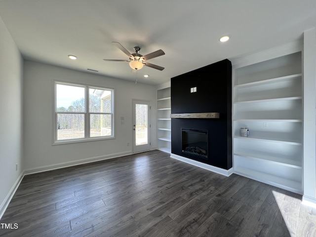 unfurnished living room with dark hardwood / wood-style flooring, built in shelves, a fireplace, and ceiling fan